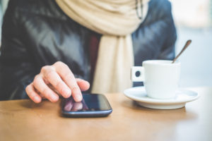 Is it time to find another job - girl checking her work phone drinking coffee